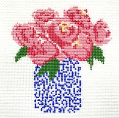 a cross - stitch picture of pink roses in a blue vase with the words happy new year written on it