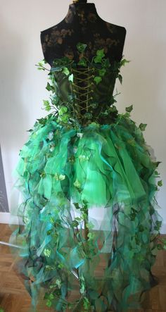 a dress made out of green leaves on top of a mannequin