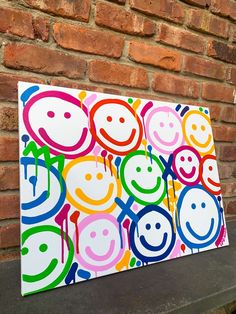 a painting on a brick wall with smiley faces