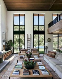 a living room with couches and tables in front of large windows that look out onto the outdoors