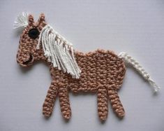 a crocheted brown horse with white wings on it's body and tail