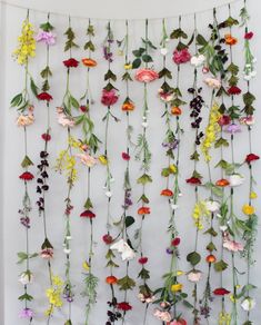 a wall hanging with flowers on it and vines attached to the back of it's sides