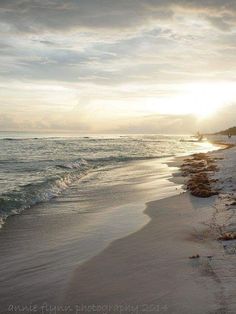 the sun is setting over the water at the beach