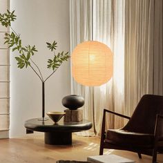 a living room filled with furniture and a lamp on top of a wooden table next to a window