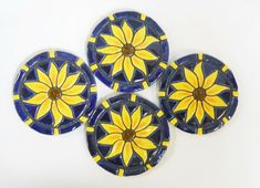 four blue and yellow plates sitting on top of each other