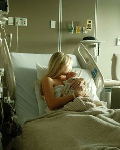 a woman laying in a hospital bed holding a baby