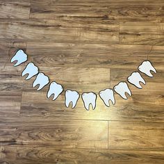 paper cut out animals are hanging from a string on a wood floor with the word halloween spelled in white