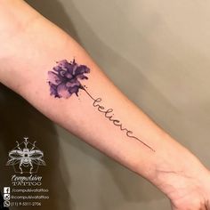 a watercolor tattoo with the word believe written in cursive writing and a purple flower