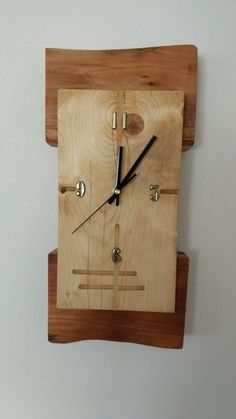 a square wooden clock mounted to the side of a wall with black hands and numbers