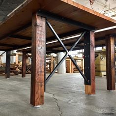 an empty warehouse with wooden beams and metal bars on the bottom half of the structure