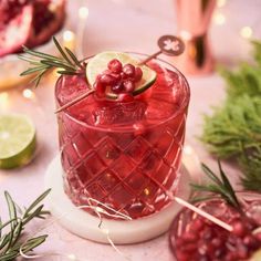 a red drink with lime and cranberry garnish