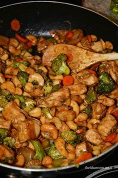 stir fry with chicken, broccoli and carrots in a wok on the stove