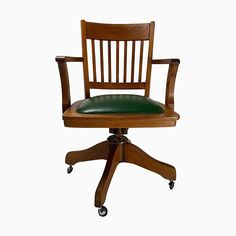 a wooden desk chair with green leather seat