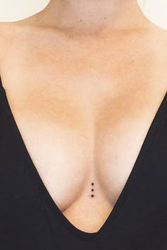 a close up of a woman's breast with small black dots on her chest