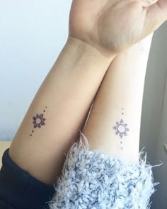 two people with matching tattoos on their arms