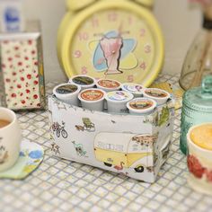 a table topped with lots of different types of cups and saucers next to a clock