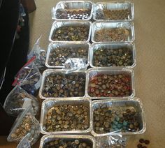 several plastic containers filled with lots of different types of buttons and other items on the floor