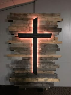 a cross made out of wooden planks with light coming from it's center