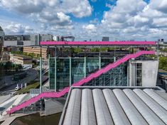 an aerial view of the roof of a building with pink painted stairs leading up to it