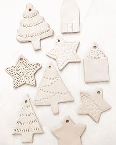 white ceramic ornaments are arranged on a table with one ornament in the shape of a christmas tree