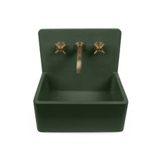 a green sink with two brass faucets on the sides and a white background