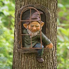 a statue of an old man in a cage on a tree