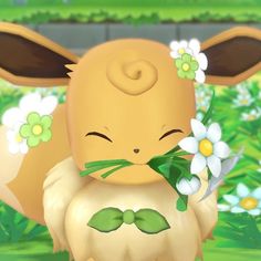 an animal with flowers in it's mouth is standing on the grass and has its eyes closed