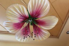 a white and pink flower hanging from the ceiling