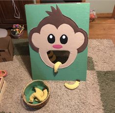 there is a cardboard box with a monkey face on it and bananas in the bowl