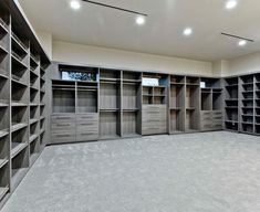 an empty walk in closet with lots of shelves and drawers on the walls, along with carpeted flooring