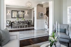 a living room filled with furniture and a chandelier hanging from the side of a wall