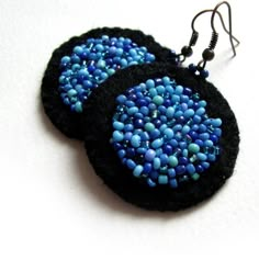 two black and blue earrings with beads on them