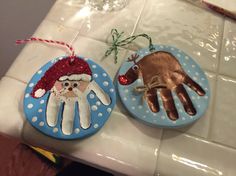 two handprinted ornaments are sitting on the counter