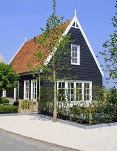 a black house with red roof and white windows