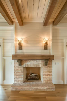 a brick fireplace with two lights on each side and wood beams above the fire place