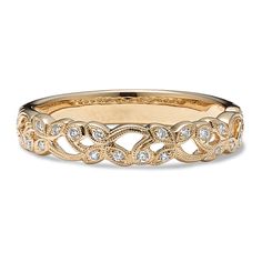 a gold wedding band with diamonds on the sides and an intricate design in the middle