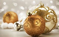 three christmas ornaments sitting next to each other on top of a white and gold table