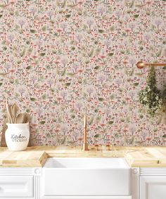 a kitchen with a sink, faucet and wallpaper in the back ground