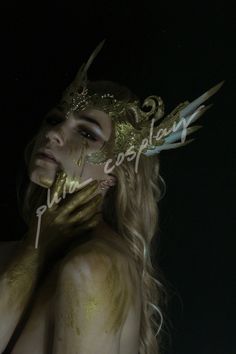 a woman with gold paint on her face and hands