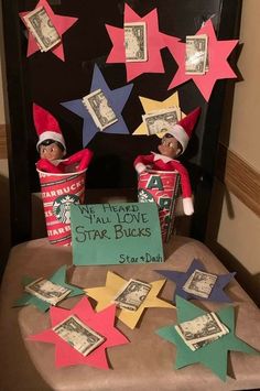 two elfs sitting on top of a chair with money in their hands and one has a sign that says we heard you all love star bucks