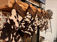 several cow print stockings hanging from a fireplace