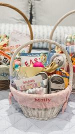 two wicker baskets filled with various items on a tableclothed surface, next to each other