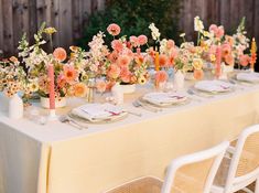 the table is set with flowers and candles for an elegant dinner party or celebration in pastel colors