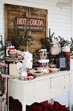 an american farmhouse style christmas display in front of a wooden sign with hot cocoa on it