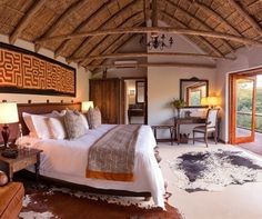 a bedroom with a large bed sitting under a thatched roof