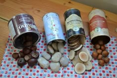 nuts and other food items are on a checkered tablecloth next to two cans of nut butter