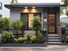 a house that has plants in the front yard and stairs leading up to the door