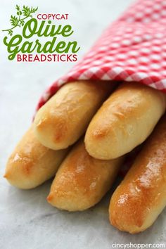 four breadsticks in a red and white checkered bag with the words copycat olive garden breadsticks