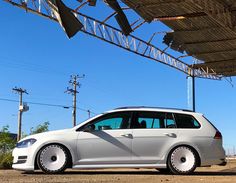 a white car is parked under an awning in front of some power lines and telephone poles