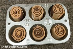 a muffin tin filled with rolled up cinnamon rolls